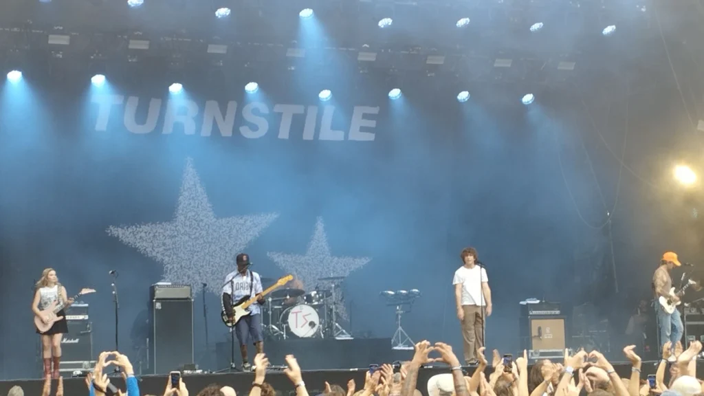 Turnstile performing on a festival stage under blue lighting