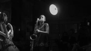 Zoh Amba performing on saxophone in an intimate venue