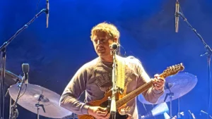 Sturgill Simpson playing guitar on stage under blue lighting