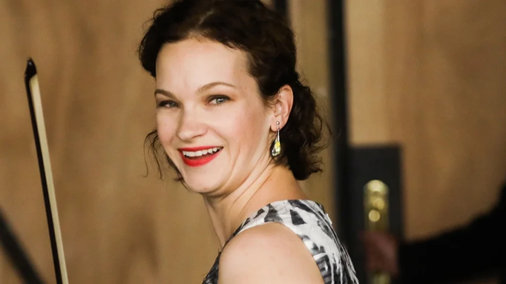 Hilary Hahn smiling, holding a violin bow