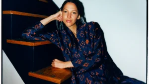 Nala Sinephro photographed seated on a staircase