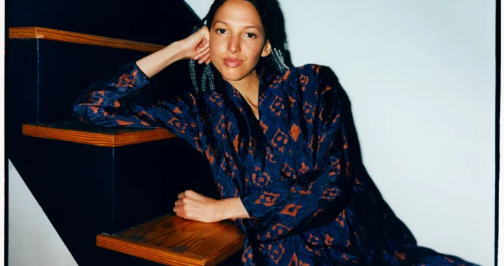 Nala Sinephro photographed seated on a staircase