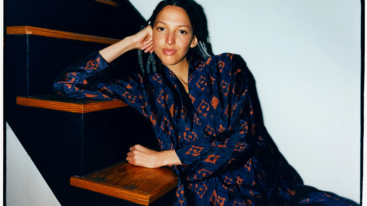 Nala Sinephro photographed seated on a staircase