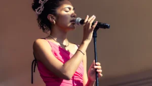 Olivia Dean singing into a microphone on stage